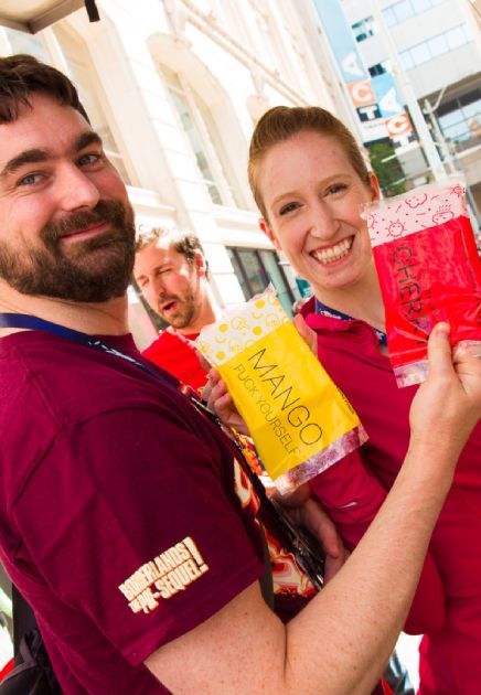 Young man and woman holding up ice pops with card games packaged inside
